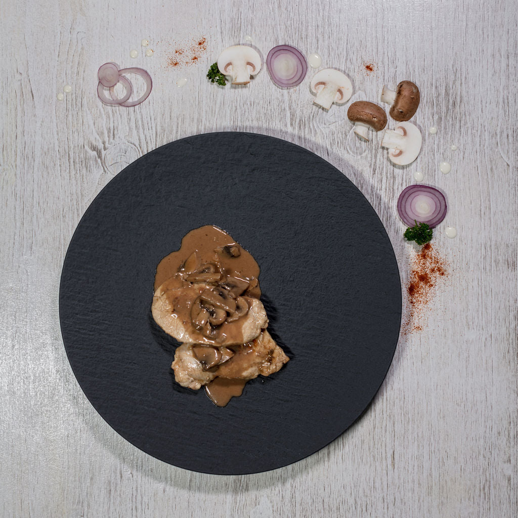 Rahmschnitzel Schweinefleisch auf Schwarzem Schieferteller angerichtet