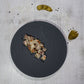 Kalbskopf im Kräuter-Gemüsesud auf schwarzem Teller angerichtet