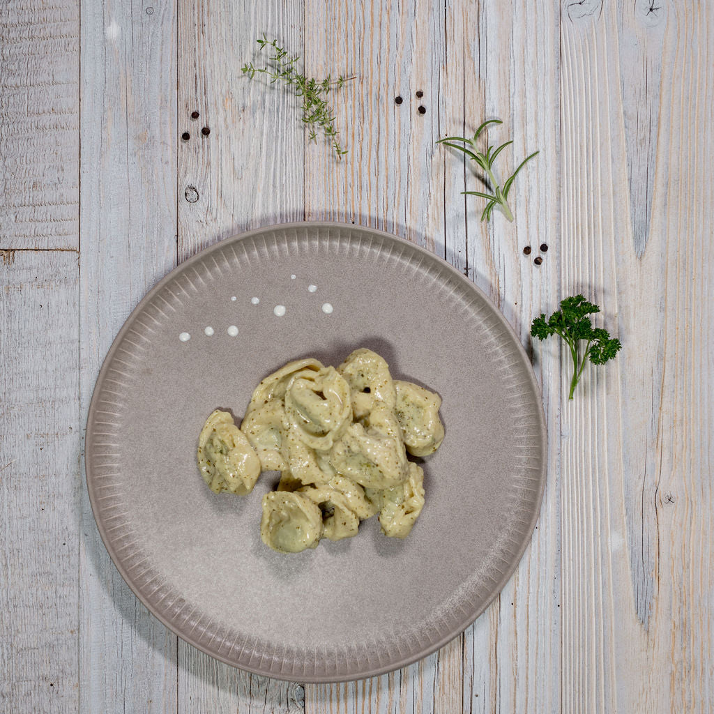Tortelloni an Kräutersauce angerichtet auf einem Teller
