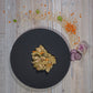 Poulet-Ragout mit Quinoa und Aprikosen auf einem Schieferteller angerichtet