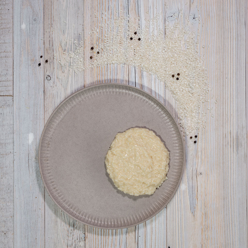 Risotto nature auf grauem Teller angerichtet