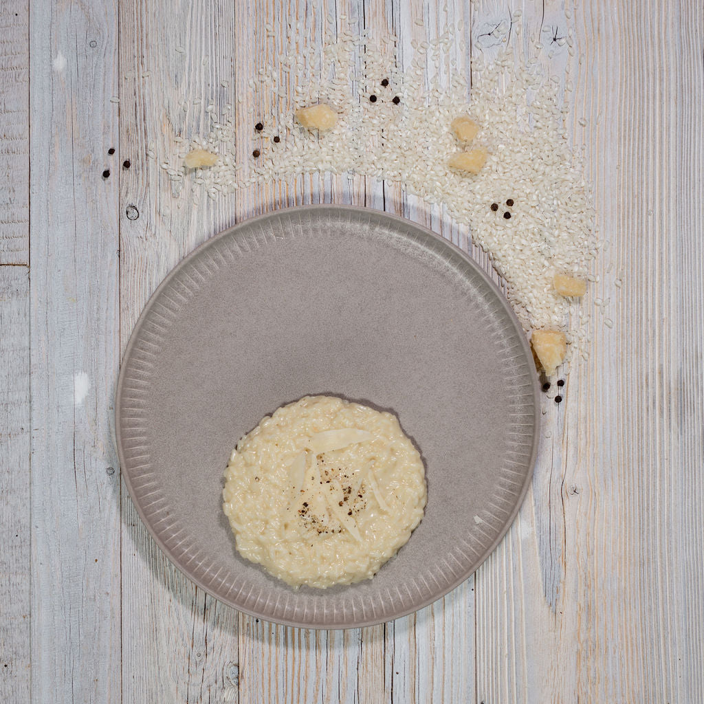 Risotto mit Sbrinz auf grauem Teller angerichtet
