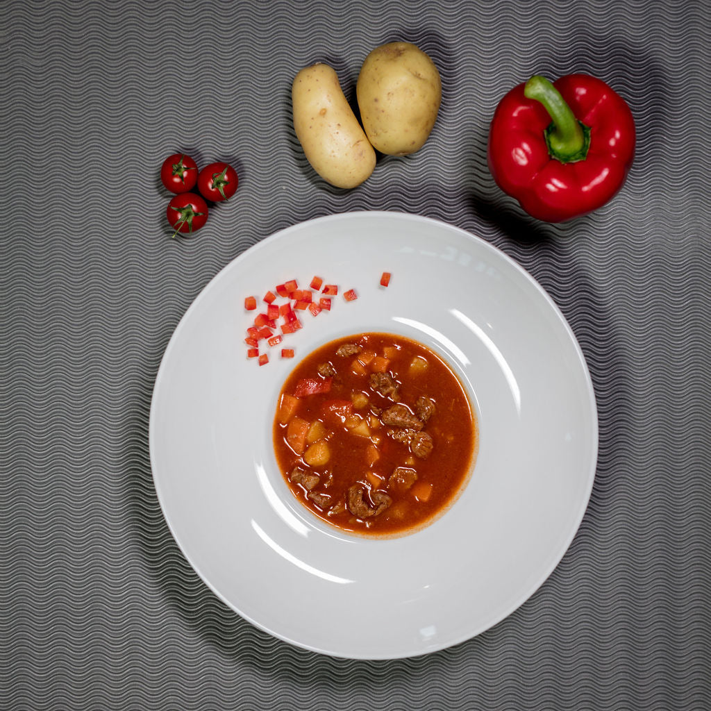 Gulaschsuppe Rind angerichtet mit Paprika und Kartoffeln